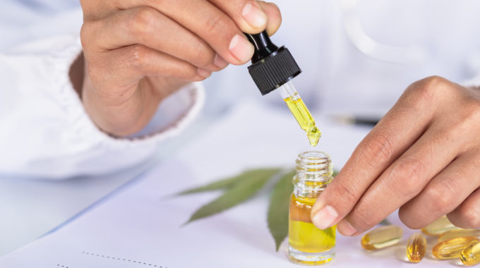 Researcher Using A Dropper With Yellow Liquid